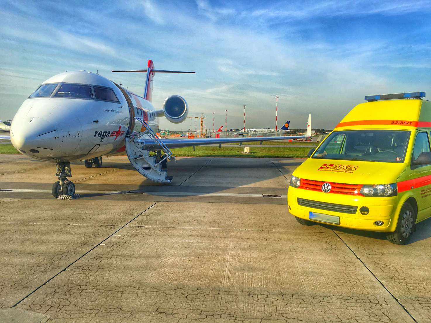 Krankentransportwagen neben Flugzeug (Foto: Daniel Hansmann für ASB Hamburg)
